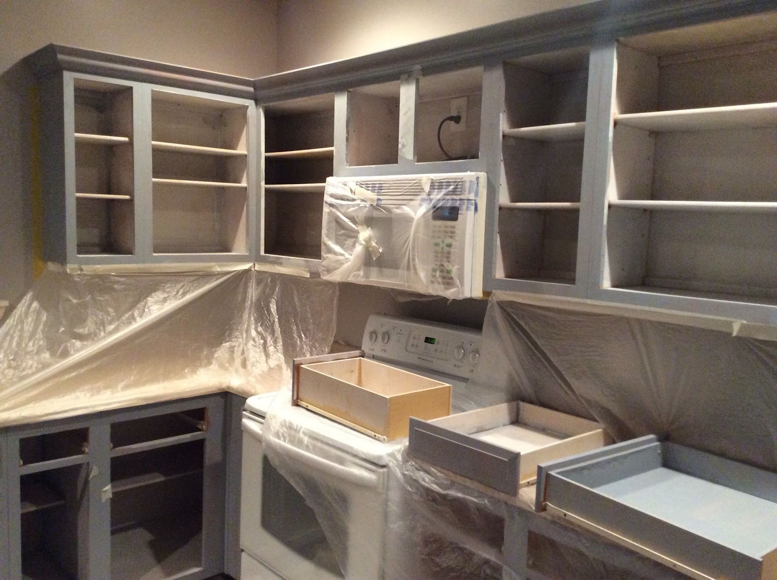 Kitchen cabinets masked off and mid-refinish