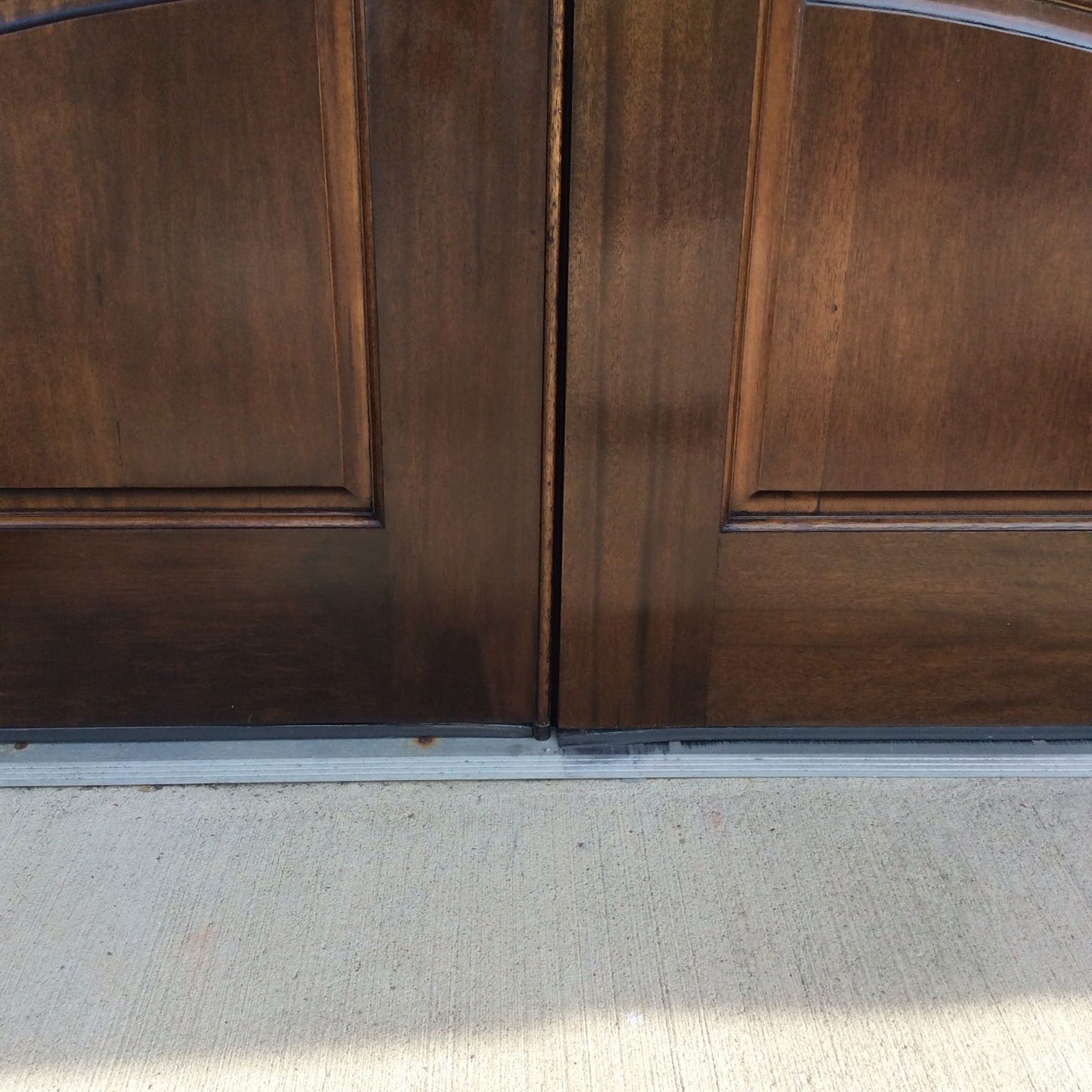 Entry door restained to a rich wood tone, close detail of the panel